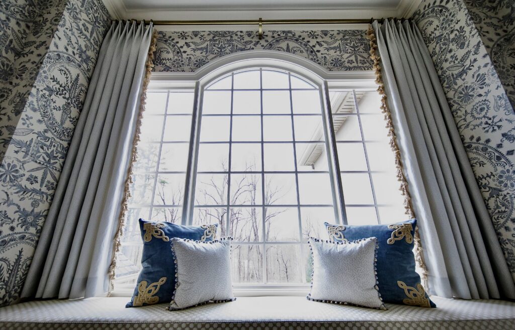 Luxury layered draperies and trim-enhanced shades showcasing maximalist interior design trends in Philadelphia.