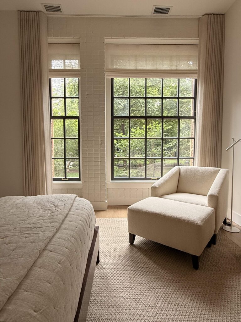 Custom woven wood Roman shades layered with ripple fold drapery panels in a bedroom, fabricated and installed by Vitalia Inc. in collaboration with Barbara Gisel Design